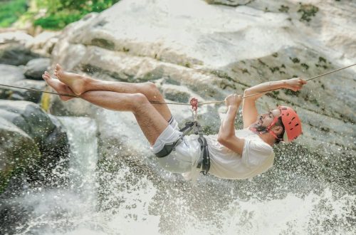 Exciting outdoor adventure of a man ziplining over a waterfall in Srinagar.